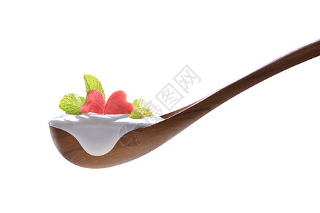 白酸奶在勺子上新鲜的心形西瓜在白背景图片