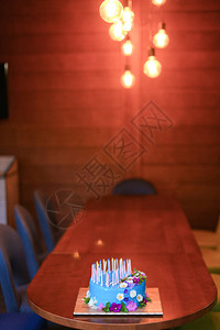 木桌上的蓝色蜡烛生日派对甜食的概念图片