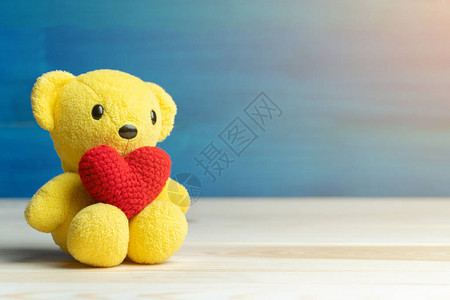 手工制作纱红心放在黄色泰迪熊上图片