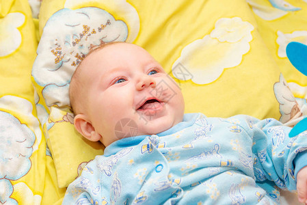 新生婴儿躺在黄色背景的婴儿床上图片