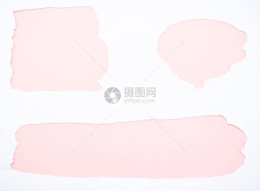 在柔和的粉红色上隔离的撕破的白纸图片