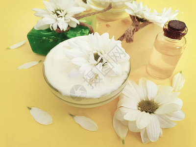 彩妆霜油肥皂菊花在彩色背景上图片