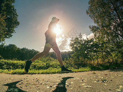 活跃男子在日出时在路上锻炼和跑图片