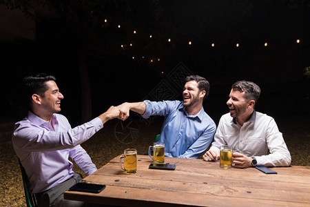 在晚间后院派对上享受啤酒时图片