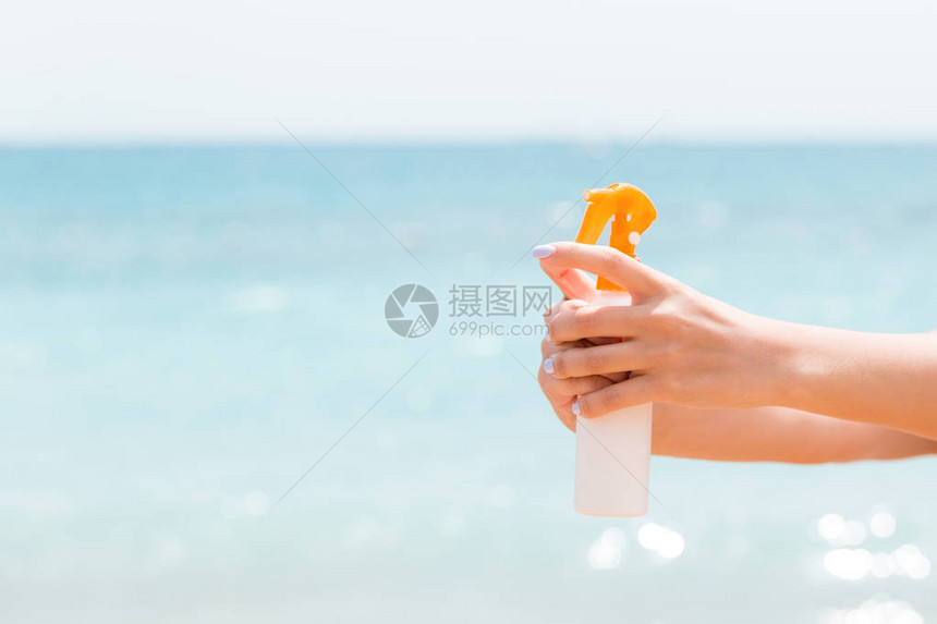 在沙滩上喷着保护身体的防晒图片