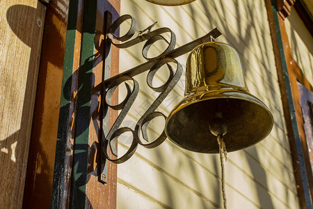 旧木屋上的老式青铜钟背景图片