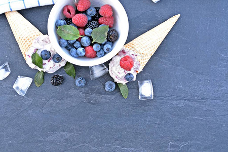 华夫冰淇淋甜筒装满森林水果冰淇淋球新鲜浆果和薄荷图片