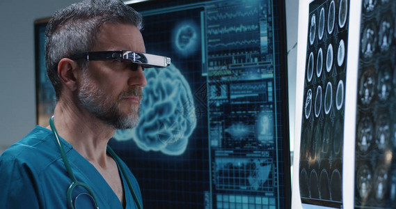一名男医生用VR头盔检查脑扫描图背景图片