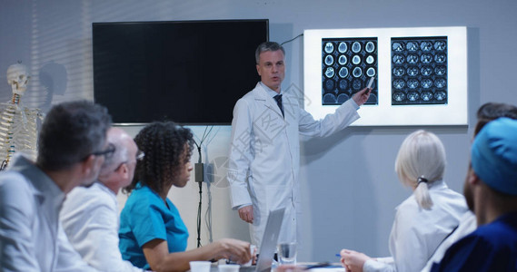 一位医生在白板上写下症状时向同事解图片