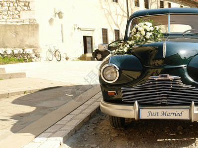 Retro经典婚礼车等待教堂大楼前的结婚夫图片