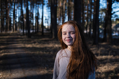 在夏天的松树公园里长着红发的可爱女学生图片