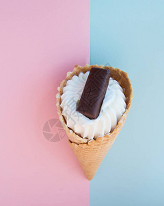 香草冰淇淋甜筒和巧克力在粉色和蓝色的糊涂背景图片