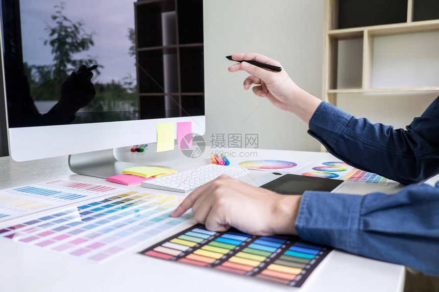 男创意平面设计师在工作场所使用工作具和配件进行颜色选择和绘图片