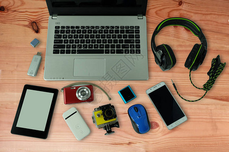 木地板背景上配有日常使用的小工具或电子设备笔记本电脑手机和数码图片