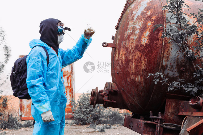 身穿蓝色防护服的男子在被毁的旧工厂测试脏水环境污染和生图片