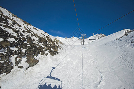 高山脉上乘坐椅子起重滑雪扶梯行驶时图片