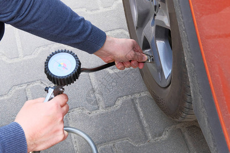 汽车服务人检查车胎的压力手接汽车轮图片