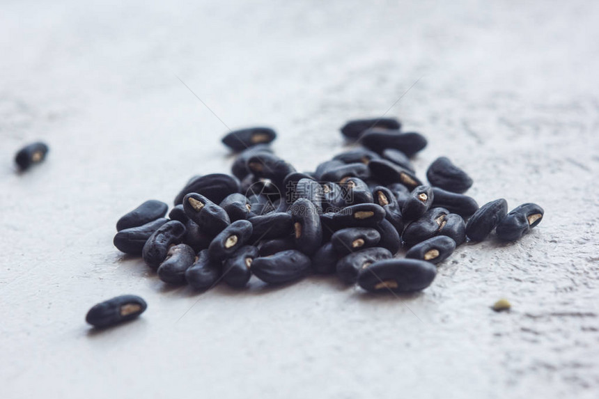 一大堆干燥的黑哈里科特种子紧贴在白桌背景上豆类播种季节关闭顶层视图片