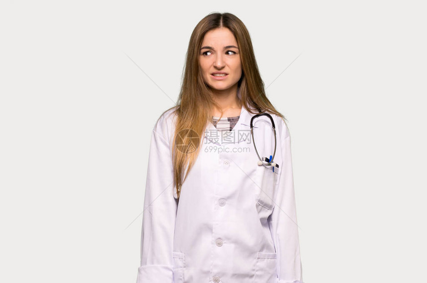 年轻的女医生有点紧张害怕在孤立的灰图片
