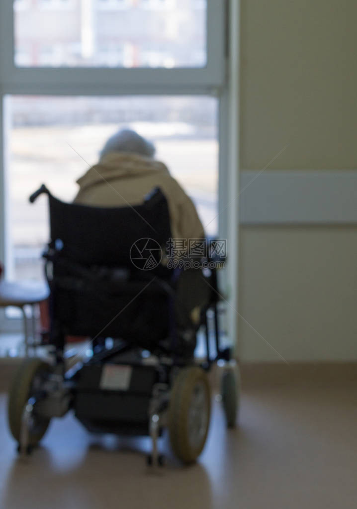 在医院里一个坐在轮椅上坐着的老人向窗图片