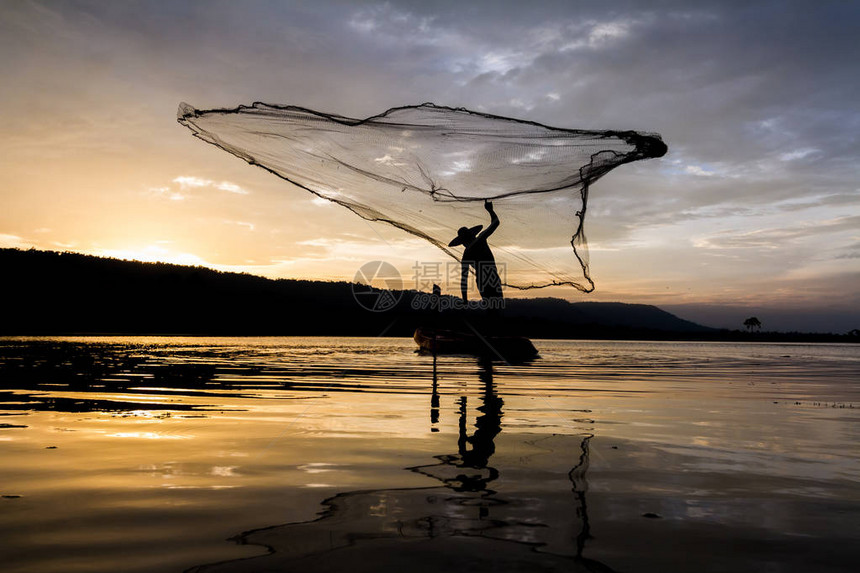 日落时捕渔时Asia渔民的图片