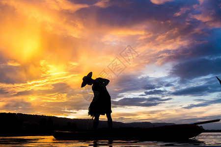 日落时捕渔时Asia渔民的图片