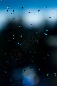 一堆透明的雨滴在模糊的玻璃上图片