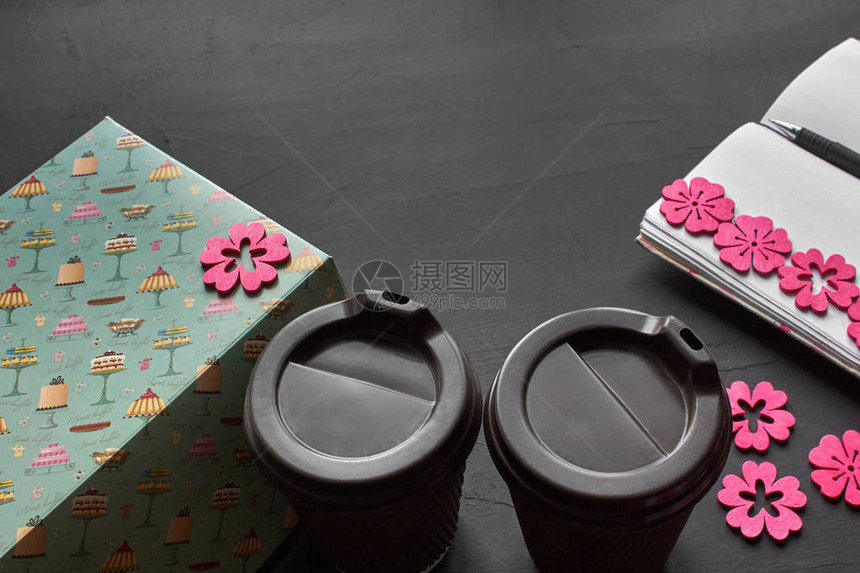 双杯咖啡空纸条粉红色剪贴本和黑色背景的蓝盒图片