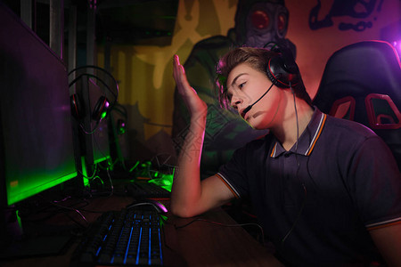 专业的年轻白种人玩家在游戏俱乐部或网络竞技场在他的个人电脑上在线玩的照片图片