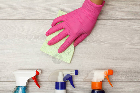 用橡胶手套持餐巾纸和木板上的洗涤剂瓶清洁工具和设备图片