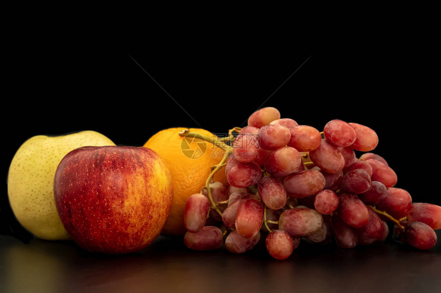 黑色背景上的橙子葡萄苹果和梨花图片