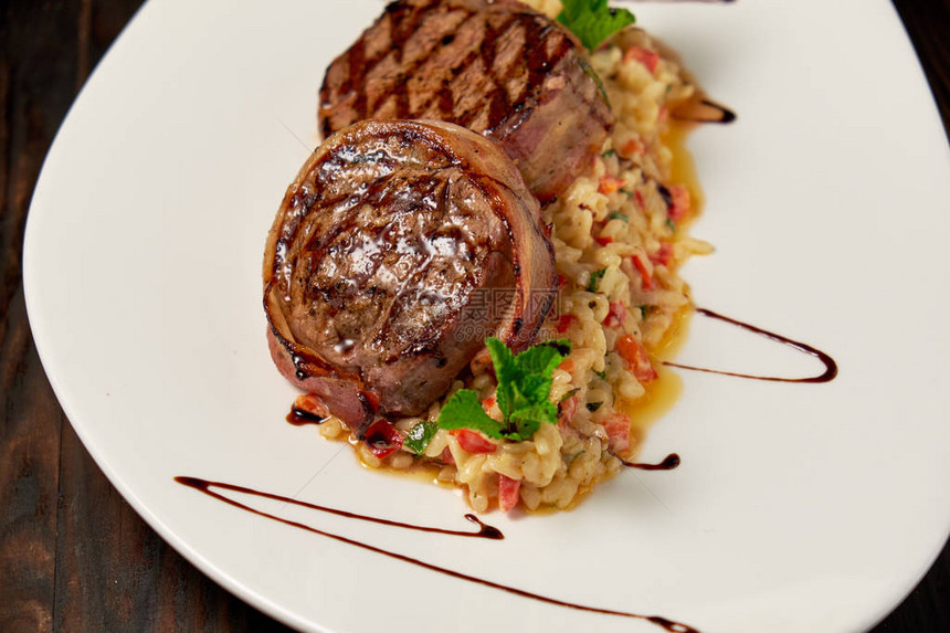 白盘上的培根肉配米饭深色木质背景餐厅菜单图片