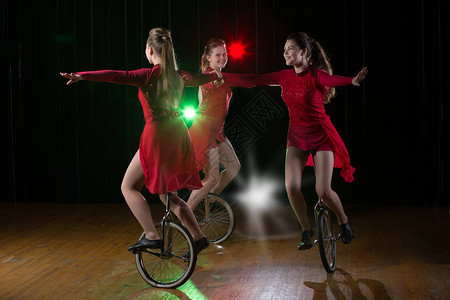 小演员表演独轮车3个女孩在舞台上表演单轮赛背景