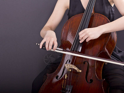 在黑暗中拉大提琴的年轻女孩大提琴手图片