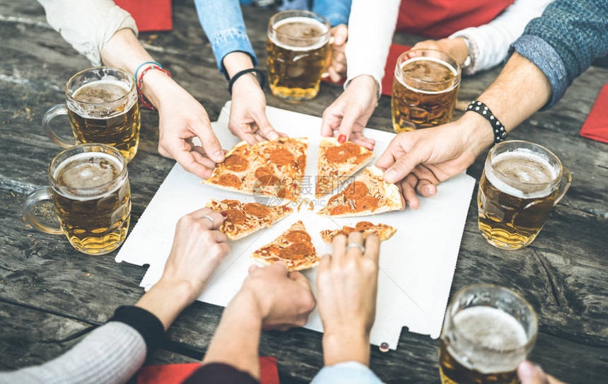 朋友团体在酒吧餐厅喝啤酒和分享披萨切片友谊概念与年轻人一起玩乐在里士大酒馆吃零食的青年友情老式对比过滤器图片