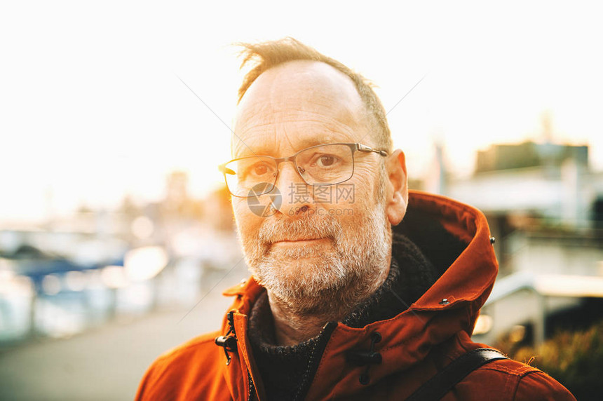 中年男子戴眼镜和橙色冬季夹克的户外肖像图片