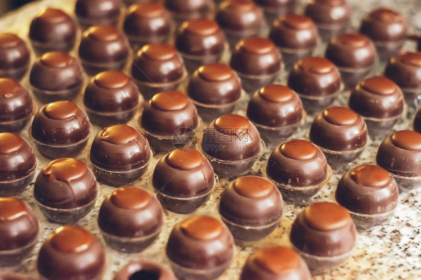 黑巧克力糖果以特殊形状排列在行内手工制做的巧克力有选择的焦点水平框图片