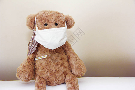 棕色软玩具熊的鼻子和医疗温度计上图片