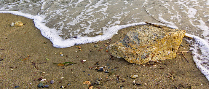 海浪直达沙滩和大石头美丽的海岸细图片