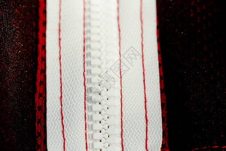 红色运动服特写顶视图错误一侧的白色拉链线透气针织品高清图片