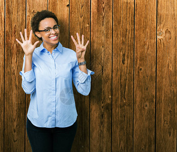 年轻美丽的非洲裔美国女商人在与世隔绝的背景下展示和指着第9号手指图片