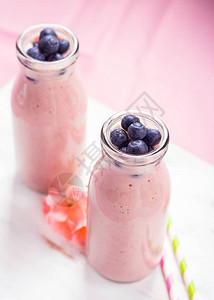 装满蓝莓的玻璃瓶里有粉色奶昔粉色花朵图片