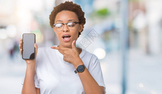 年轻非裔美国女在孤立的背景中显示智能手机屏幕图片