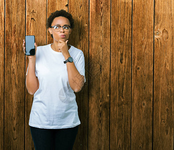 年轻的非洲裔美国女在孤立的背景下展示智能手机屏幕图片