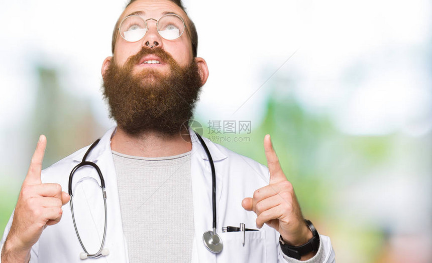 金发大胡子的金发年轻医生穿着医疗大衣图片