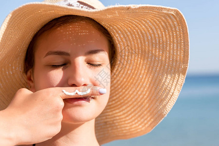 可爱的女人在海滨的鼻子下摆着胡子图片