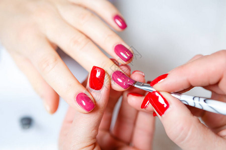 正在进行修指甲美丽的修剪过的女人的指甲用红色指甲油美容甲行业图片