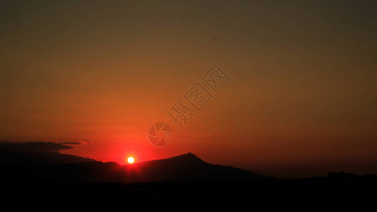 太阳在山后面落下美丽的全景图片