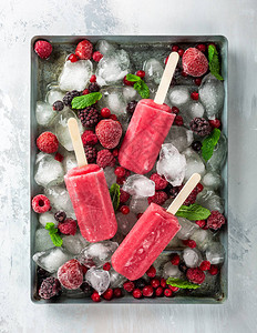 含有冰各种浆果和薄荷的金属板上的自制草莓冰棒健康图片