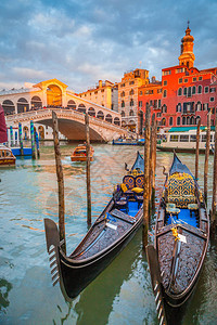 著名的大运河上的传统贡多拉与著名的里亚托桥在背景中图片